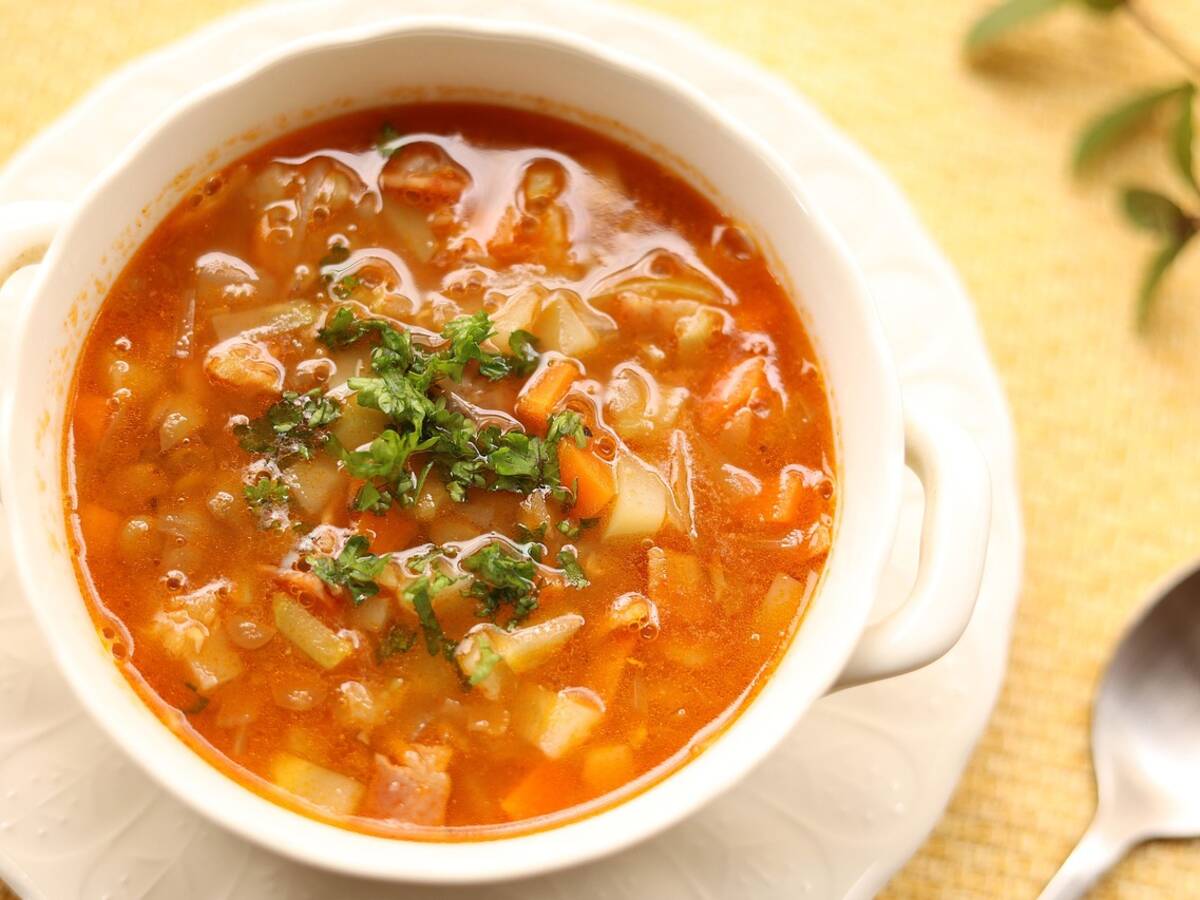 Bol de soupe de lentilles corail avec un filet d'huile pimentée et un quartier de citron