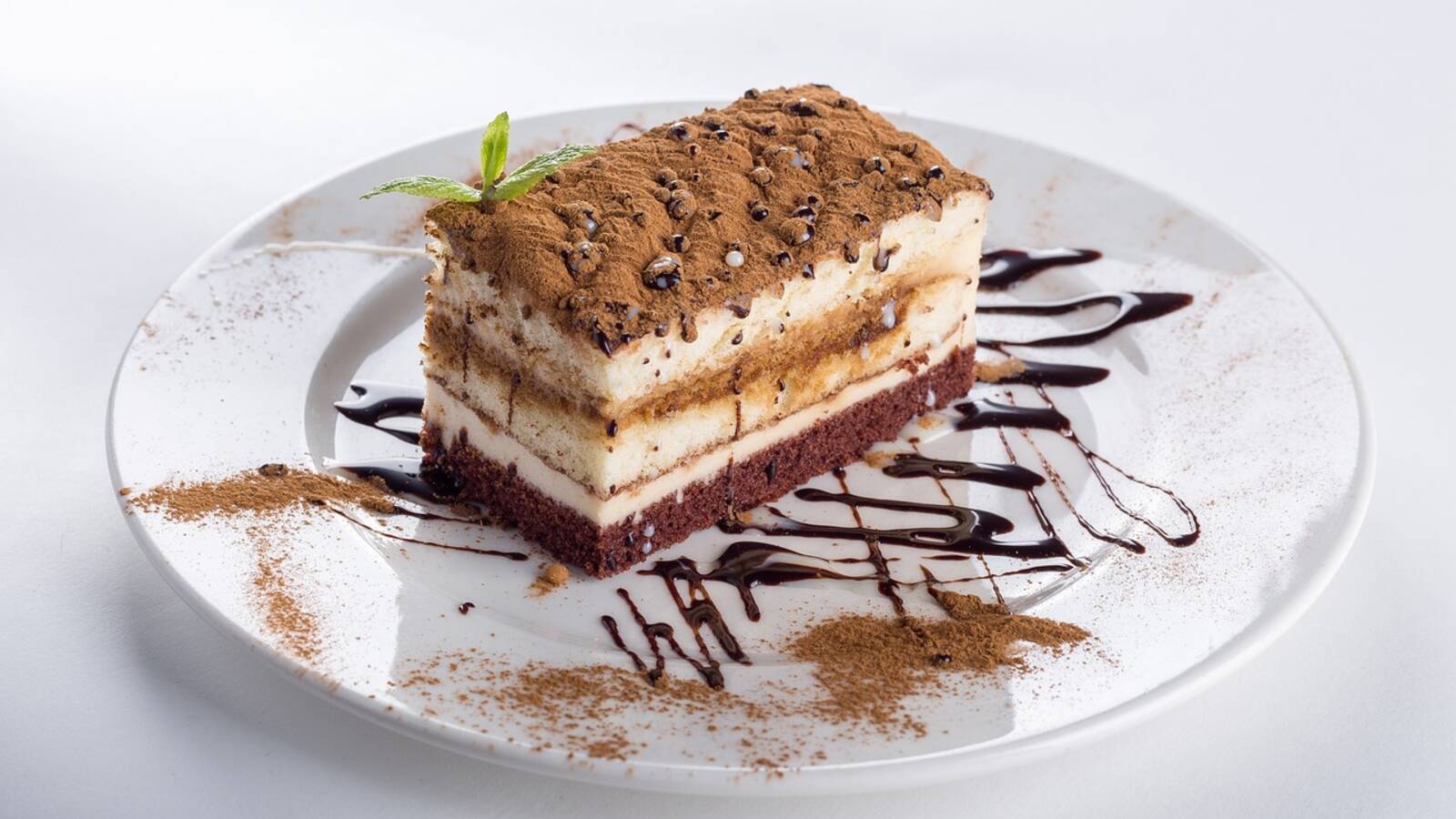 Part de tiramisu aux couches de biscuits et de crème, saupoudrée de cacao