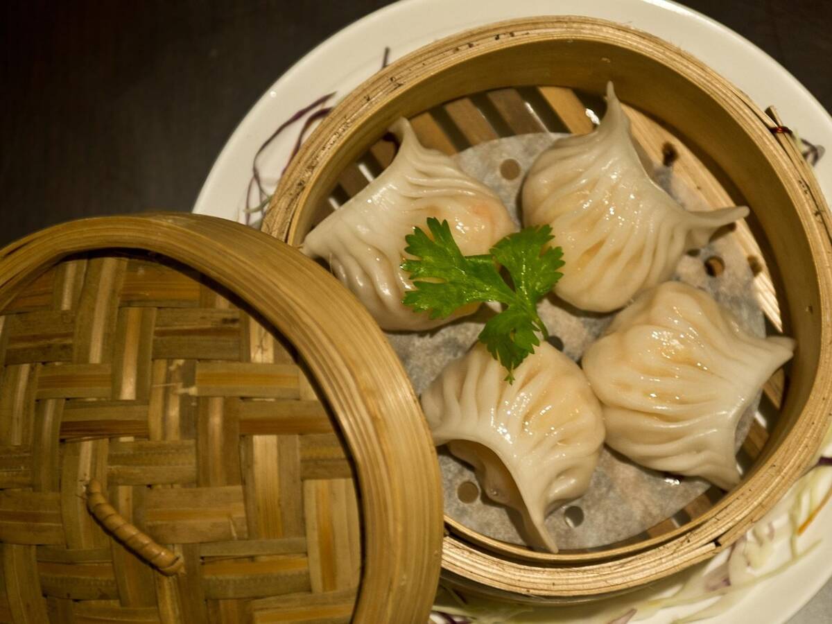Raviolis cuits à la vapeur dans un panier en bambou, la pâte devenue translucide